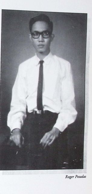 Studio portrait of a young Roger Posadas in a white shirt, thin black tie and heavy-framed glasses