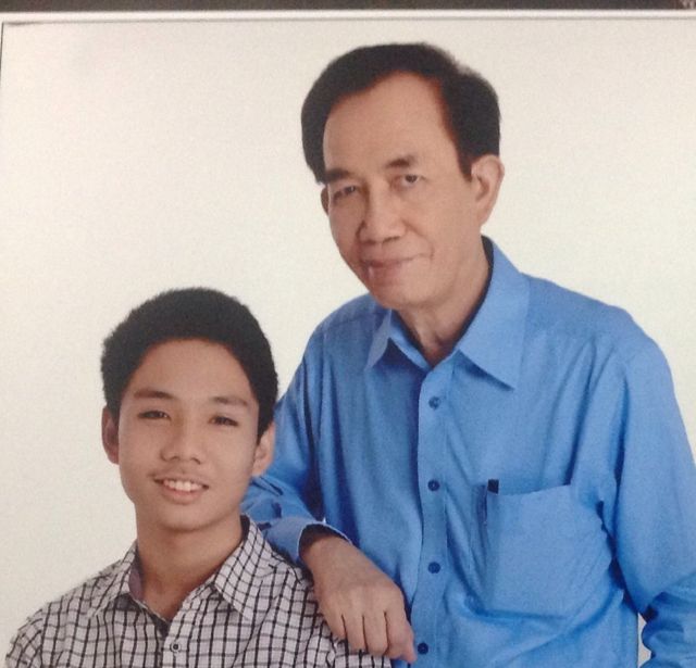 Studio portrait of Dad in a blue shirt with his arm resting on young Gregor's shoulder