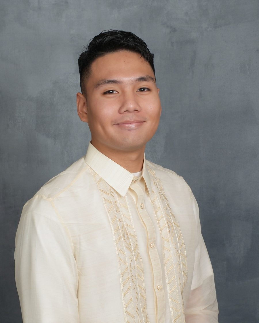 Gregor Posadas smiling in a cream barong Tagalog against a grey studio backdrop