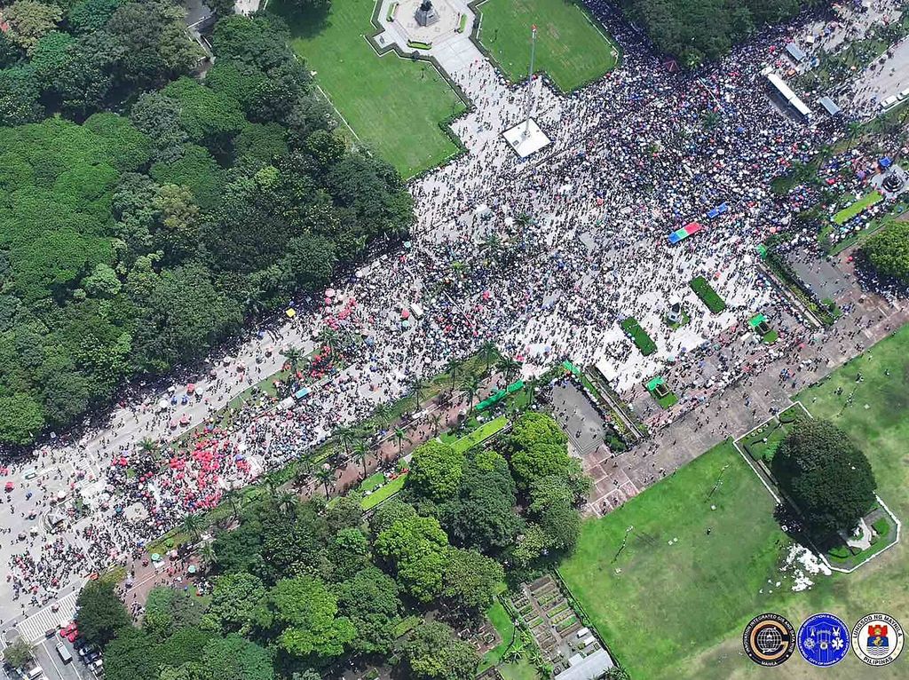 Aerial view of a large crowd filling a road and plaza in Rizal Park, Manila.